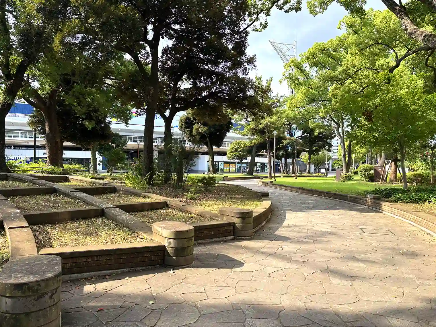木々の向こうに横浜スタジアムを望む園路